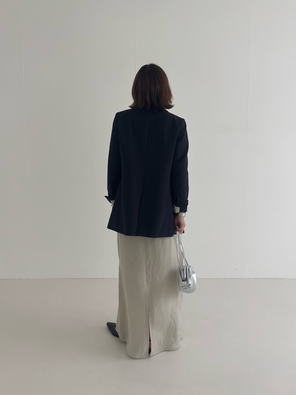 ブルー系のその他アウター、ベージュ系のスカート、ブラック系のパンプスを着用したレディースの春コーディネートの3枚目の写真