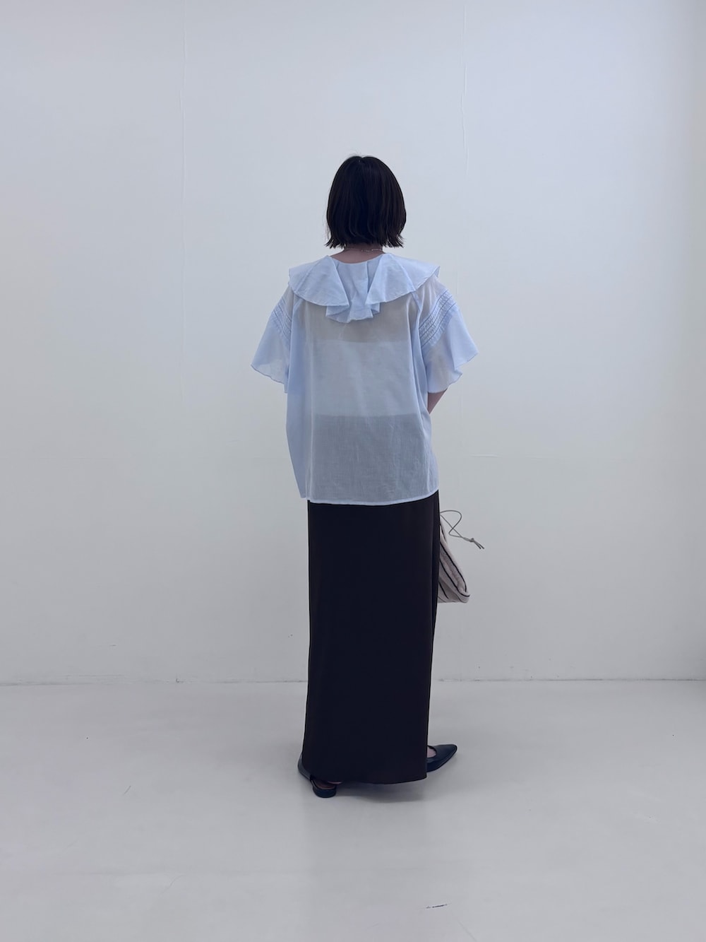 ブルー系のシャツ/ブラウス、ホワイト系のハンドバッグ、ブラウン系のスカートを着用したレディースの夏コーディネートの4枚目の写真