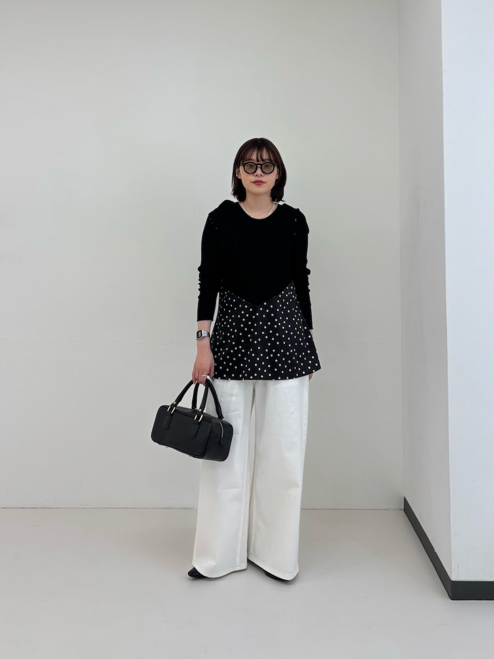 ホワイト系のデニムパンツ、ブラック系のシャツ/ブラウス、ブラック系のTシャツ/カットソーを着用したレディースの春コーディネートの2枚目の写真