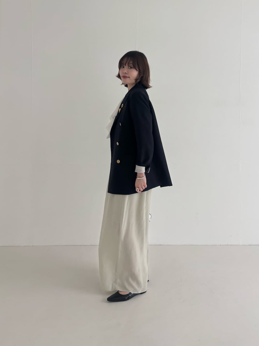 ブルー系のその他アウター、ベージュ系のスカート、ブラック系のパンプスを着用したレディースの春コーディネートの2枚目の写真