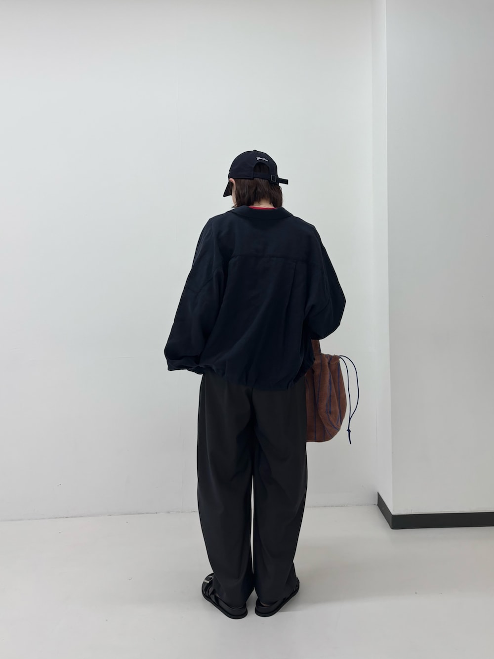 レッド系のTシャツ/カットソー、グレー系のその他パンツ、ブルー系のシャツ/ブラウスを着用したレディースの春コーディネートの2枚目の写真