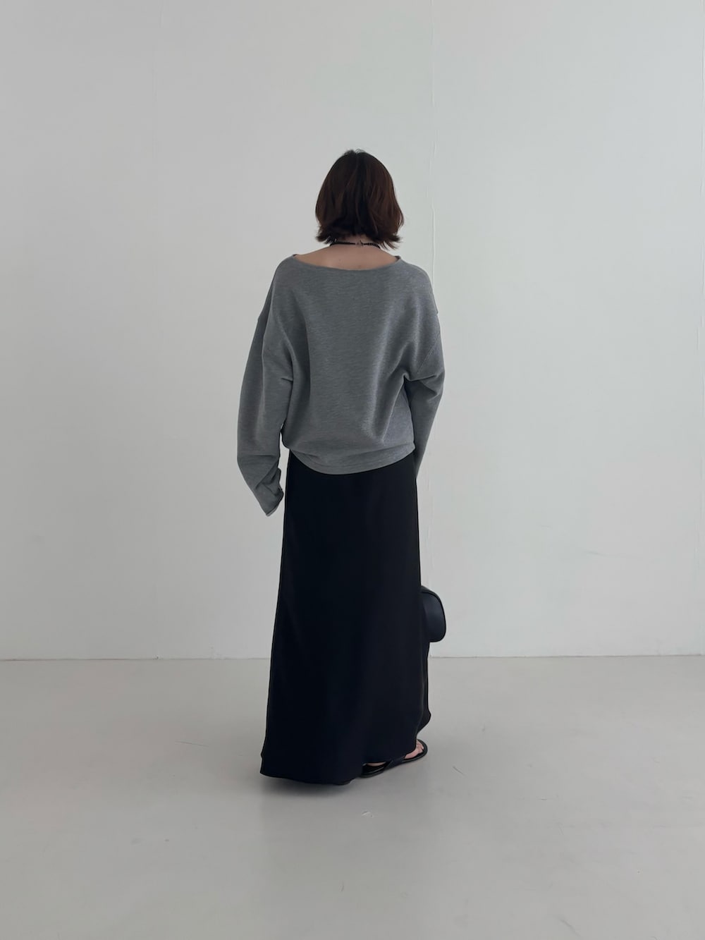 ブラック系のスカート、グレー系のスウェット、ブラック系のショルダーバッグを着用したレディースの春コーディネートの3枚目の写真