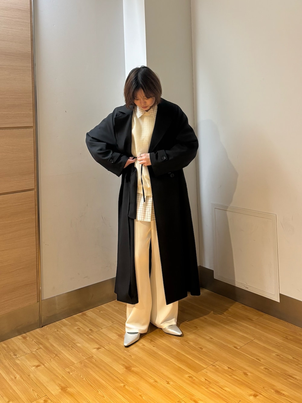 ブラック系のトレンチコート、ホワイト系のその他パンツ、ホワイト系のニット/セーターを着用したレディースの冬コーディネートの3枚目の写真