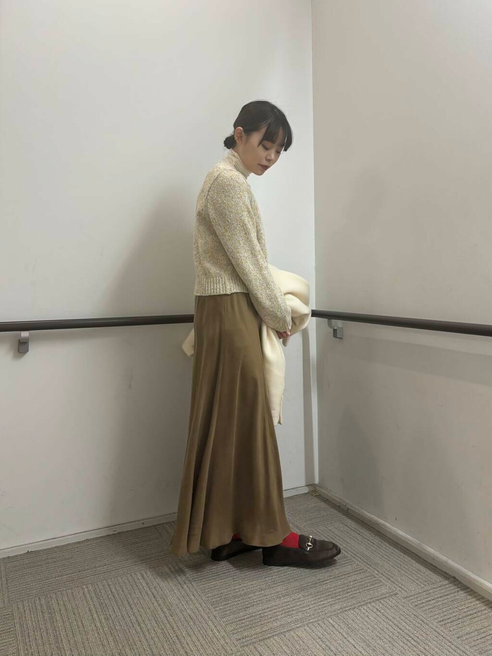 ホワイト系のその他アウター、イエロー系のスカート、ホワイト系のカーディガン/ボレロを着用したレディースの冬コーディネートの7枚目の写真