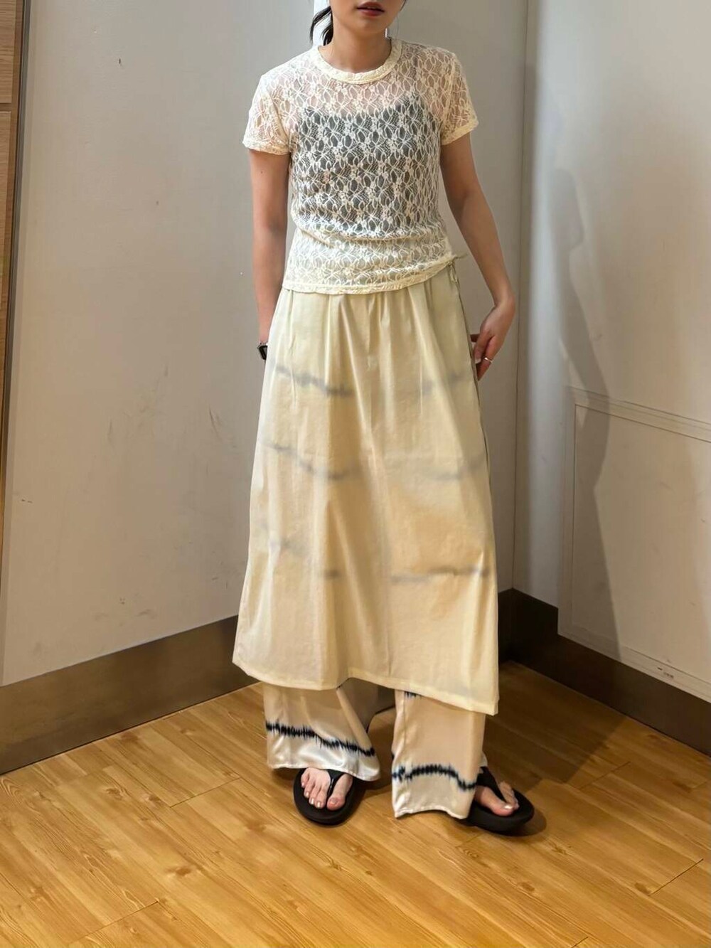 ブラック系のサンダル、ベージュ系のスカート、ホワイト系のその他パンツを着用したレディースの夏コーディネートの3枚目の写真