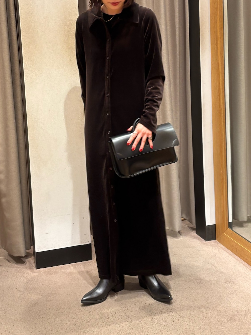 ブラウン系のワンピース、ブラック系のハンドバッグ、ブラック系のブーツを着用したレディースの秋コーディネートの2枚目の写真