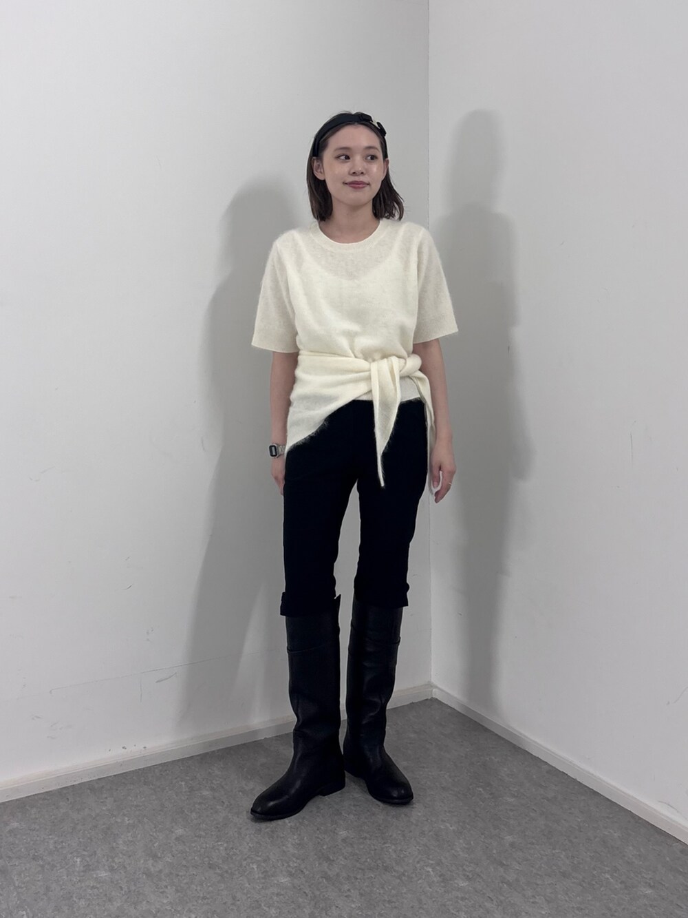 ホワイト系のニット/セーター、ブラック系のその他パンツ、ブラック系のブーツを着用したレディースの秋コーディネートの4枚目の写真