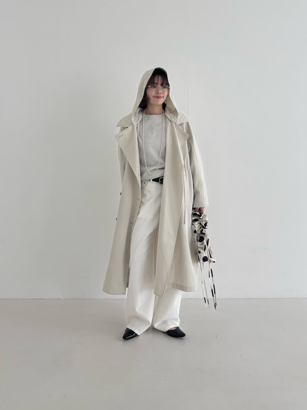 ベージュ系のトレンチコート、ブラック系のパンプス、ホワイト系のスウェットを着用したレディースの春コーディネートの4枚目の写真