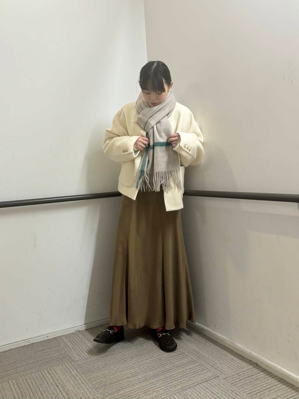 ホワイト系のその他アウター、イエロー系のスカート、ホワイト系のカーディガン/ボレロを着用したレディースの冬コーディネートの2枚目の写真