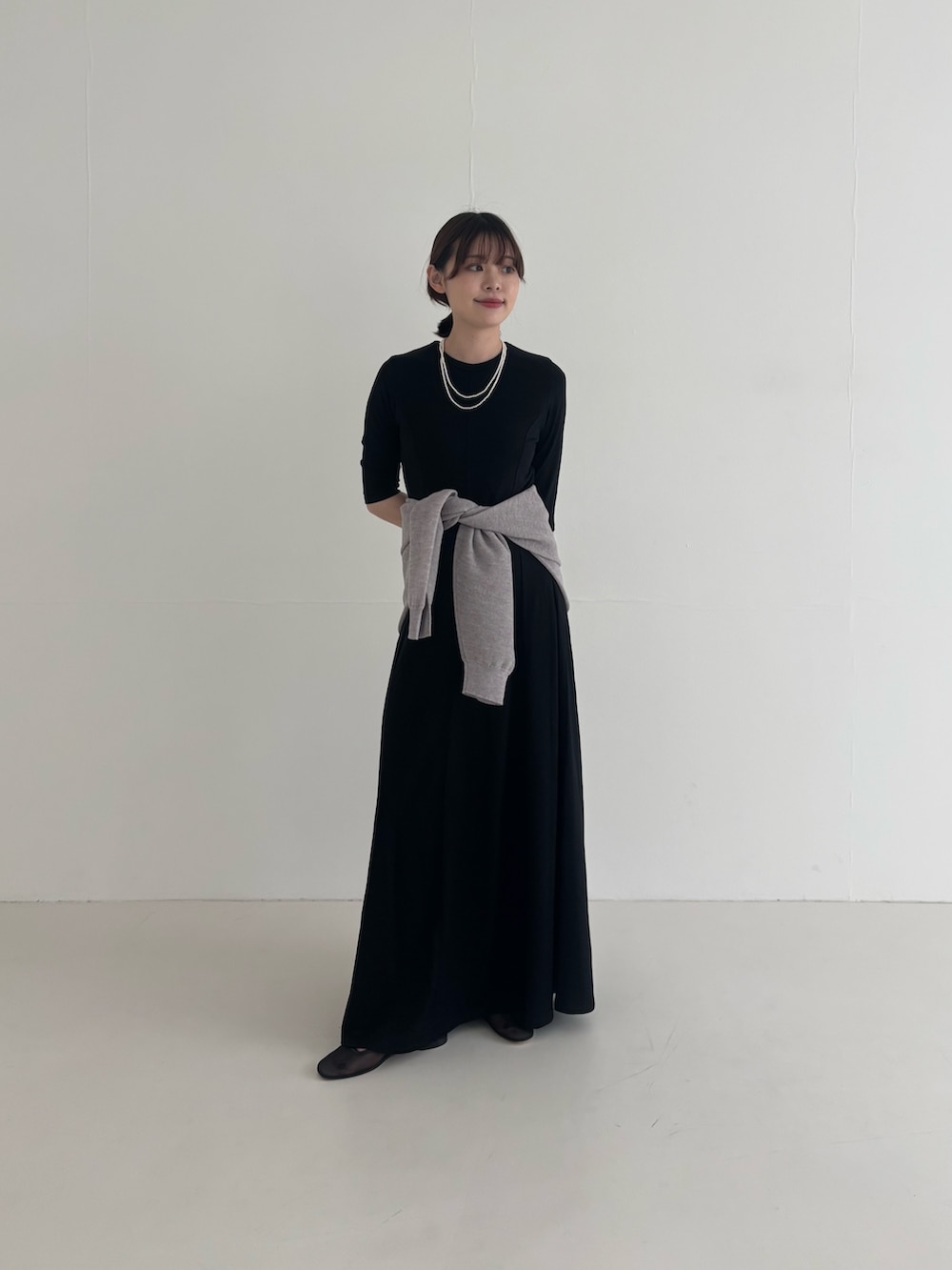 ブラック系のワンピース、ブラック系のその他アウター、グレー系のニット/セーターを着用したレディースの春コーディネートの3枚目の写真