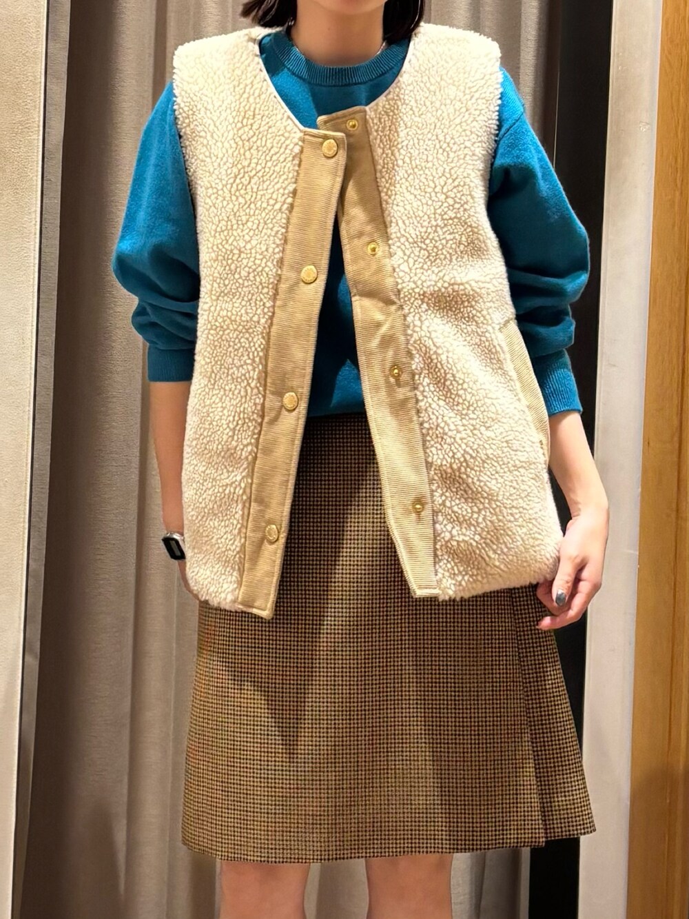 ブルー系のニット/セーター、ベージュ系のスカート、レッド系のパンプスを着用したレディースの秋コーディネートの3枚目の写真