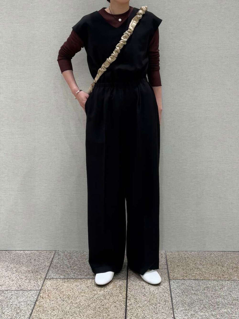 ブラウン系のTシャツ/カットソー、ベージュ系のショルダーバッグ、ブラック系のサロペット/オーバーオールを着用したレディースの冬コーディネートの4枚目の写真