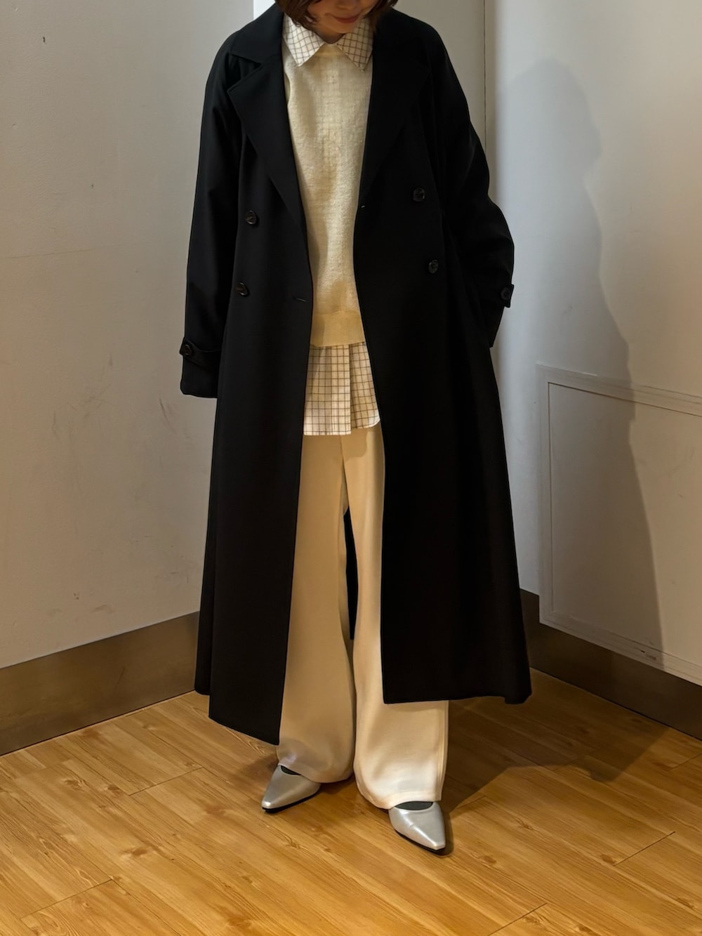 ブラック系のトレンチコート、ホワイト系のその他パンツ、ホワイト系のニット/セーターを着用したレディースの冬コーディネートの2枚目の写真