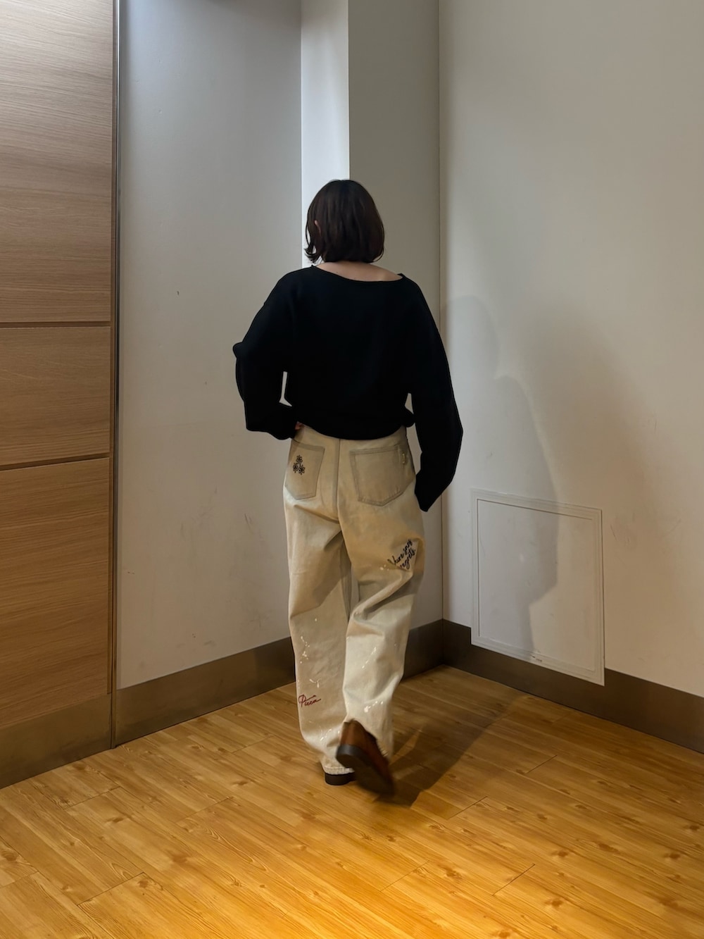 グレー系のデニムパンツ、ブラック系のスウェット、イエロー系のローファーを着用したレディースの冬コーディネートの3枚目の写真