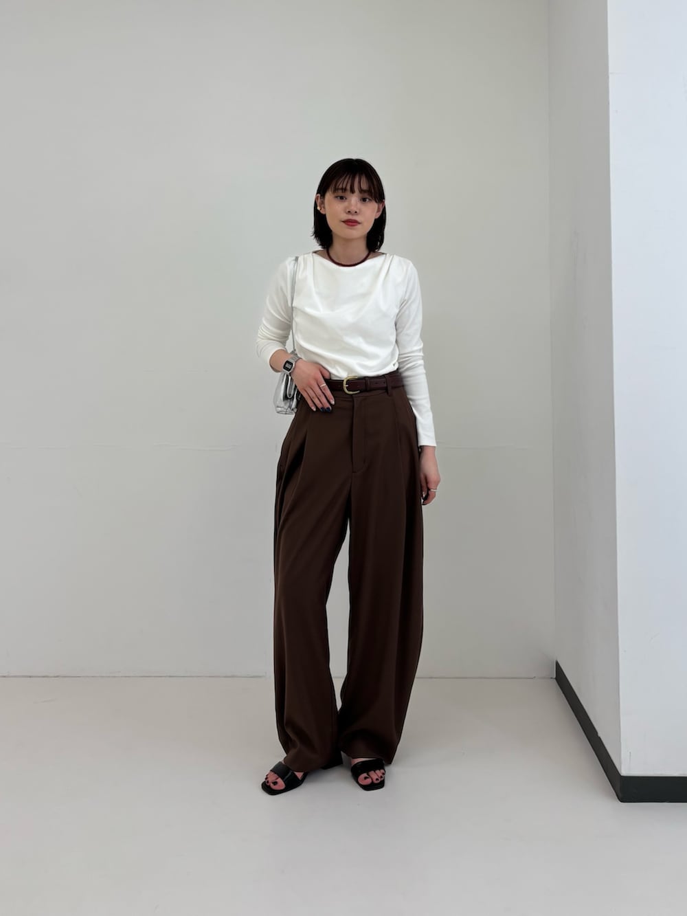 ホワイト系のTシャツ/カットソー、ベージュ系のその他アウター、シルバー系のショルダーバッグを着用したレディースの春コーディネートの3枚目の写真