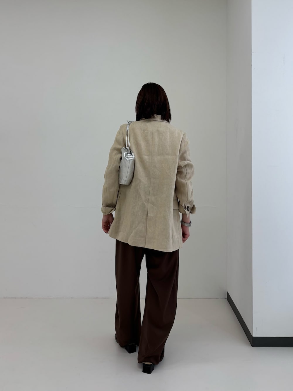 ホワイト系のTシャツ/カットソー、ベージュ系のその他アウター、シルバー系のショルダーバッグを着用したレディースの春コーディネートの2枚目の写真