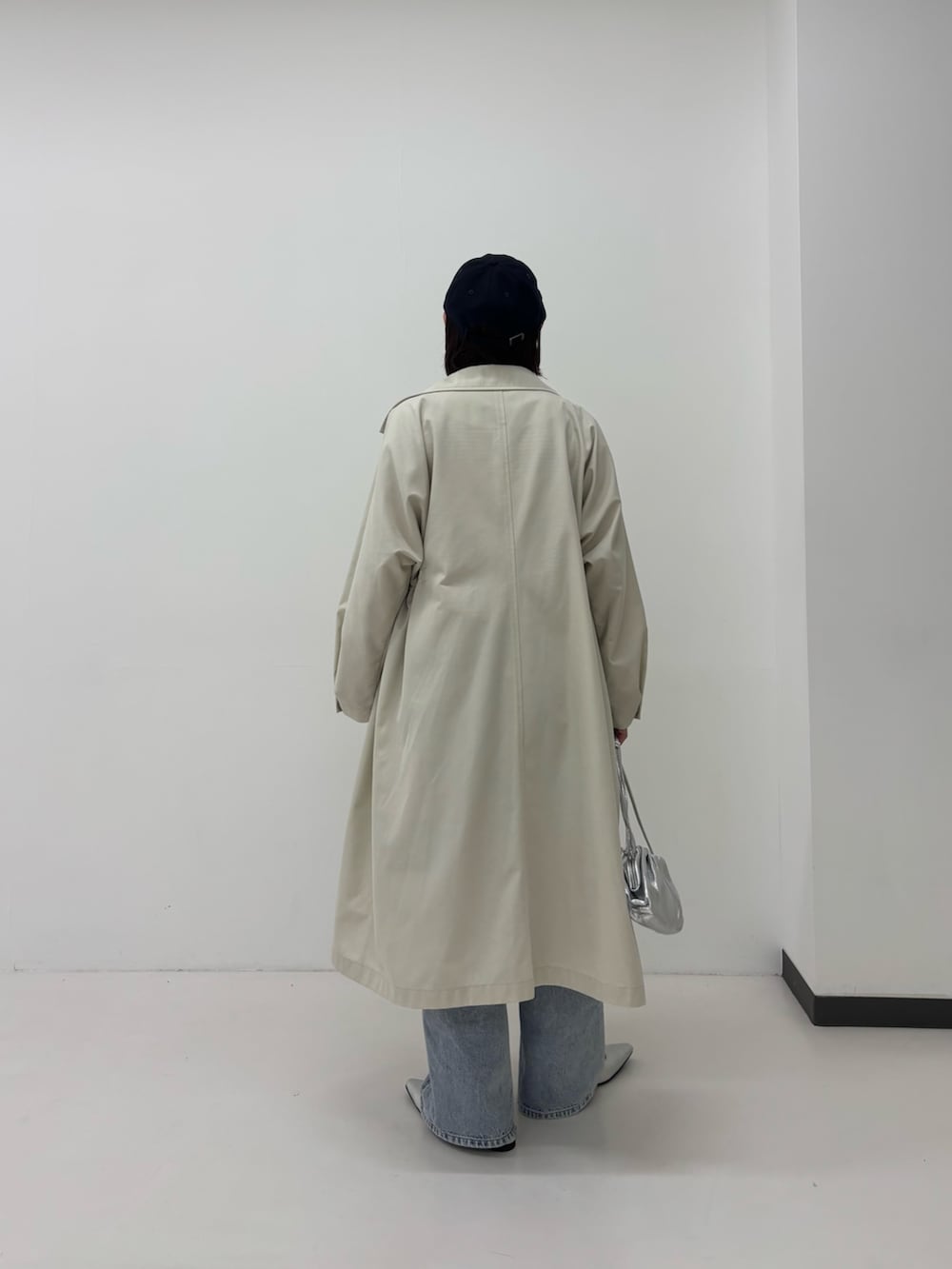ベージュ系のトレンチコート、ブルー系のデニムパンツ、レッド系のTシャツ/カットソーを着用したレディースの春コーディネートの3枚目の写真