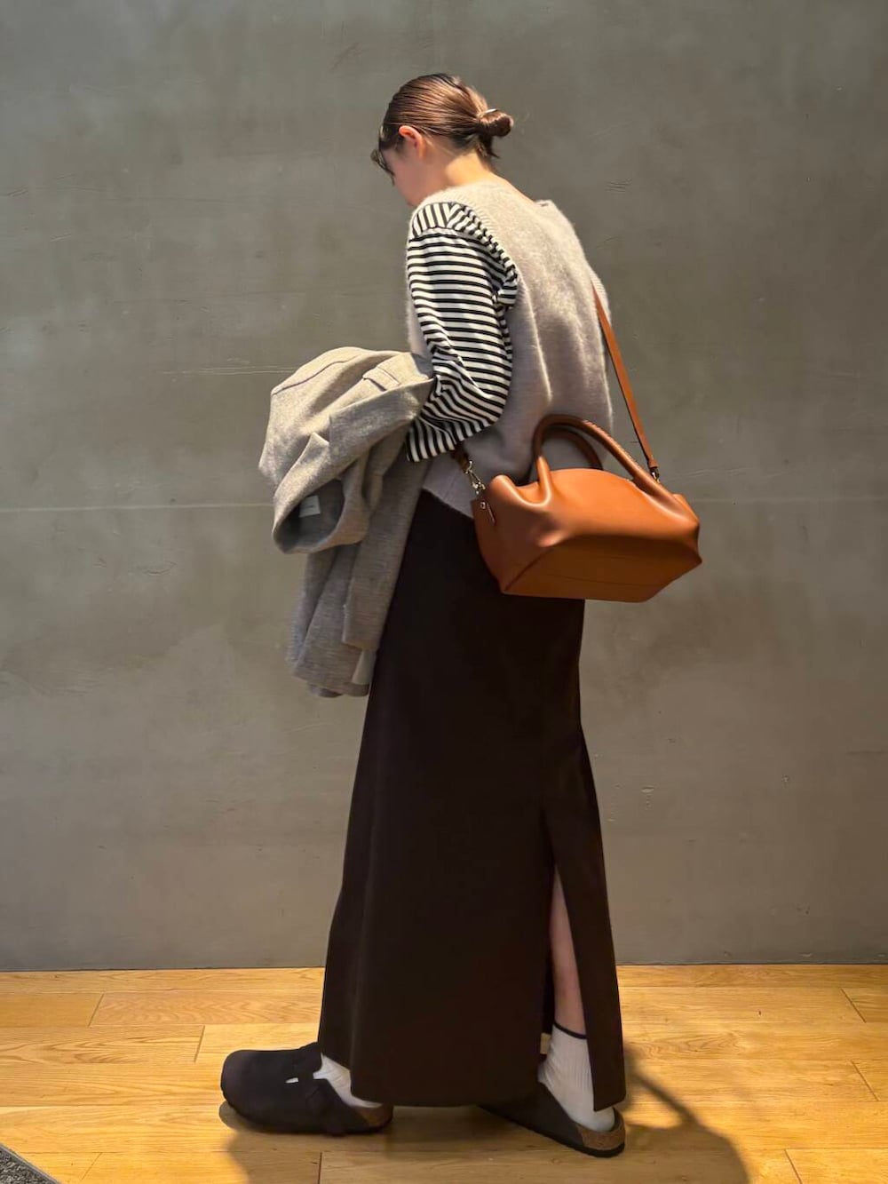 ブラウン系のスカート、グレー系のベスト、ホワイト系のTシャツ/カットソーを着用したレディースの秋コーディネートの6枚目の写真