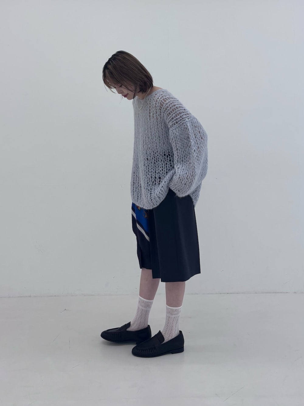ブルー系のニット/セーター、グレー系のその他パンツ、ブラック系のローファーを着用したレディースの秋コーディネートの3枚目の写真