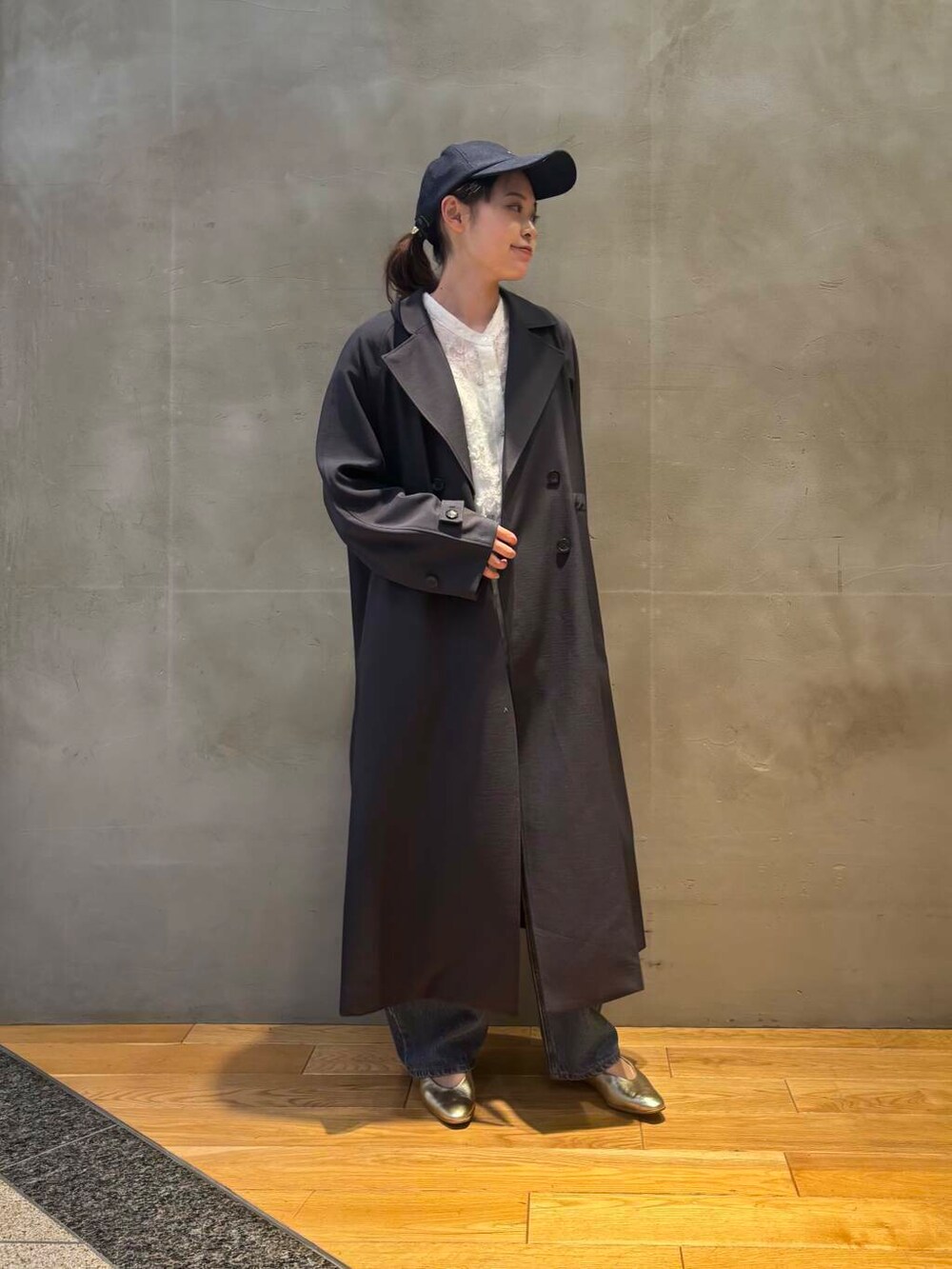 ブルー系のデニムパンツ、ホワイト系のシャツ/ブラウス、グレー系のトレンチコートを着用したレディースの冬コーディネートの2枚目の写真