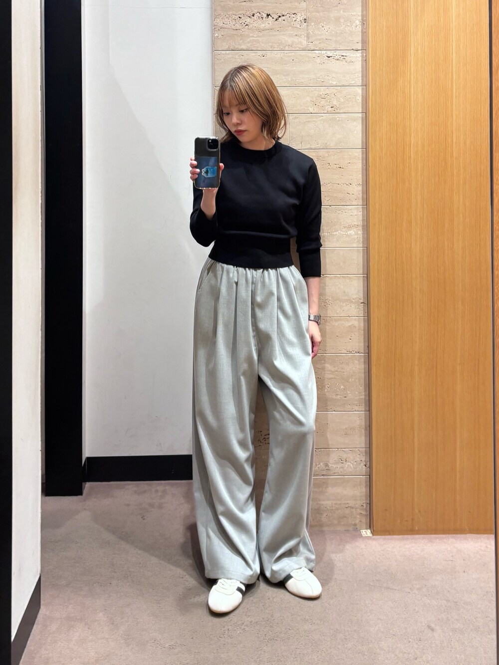 ブラック系のブルゾン、グレー系のその他パンツ、ホワイト系のスニーカーを着用したレディースの秋コーディネートの2枚目の写真