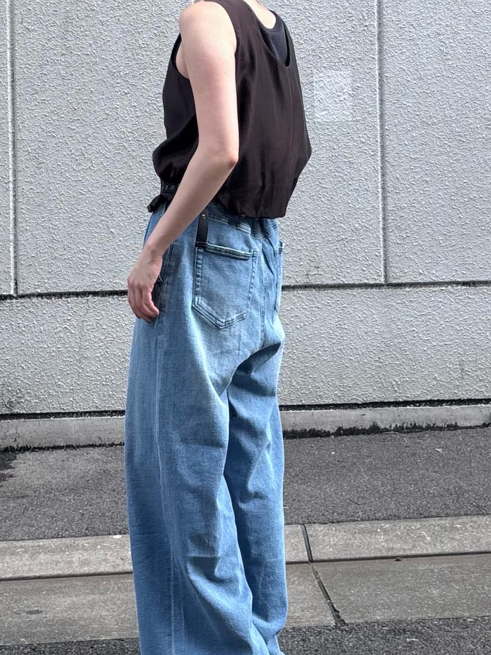 ブルー系のデニムパンツ、ブラック系のサンダル、グレー系のその他トップスを着用したレディースの夏コーディネートの2枚目の写真