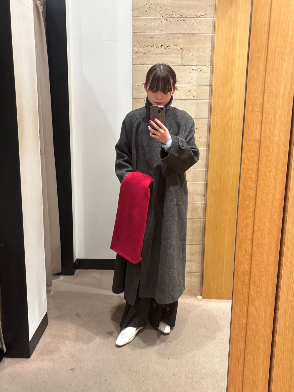 ブラック系のステンカラーコート、ブルー系のTシャツ/カットソー、ブラック系のその他パンツを着用したレディースの冬コーディネートの4枚目の写真