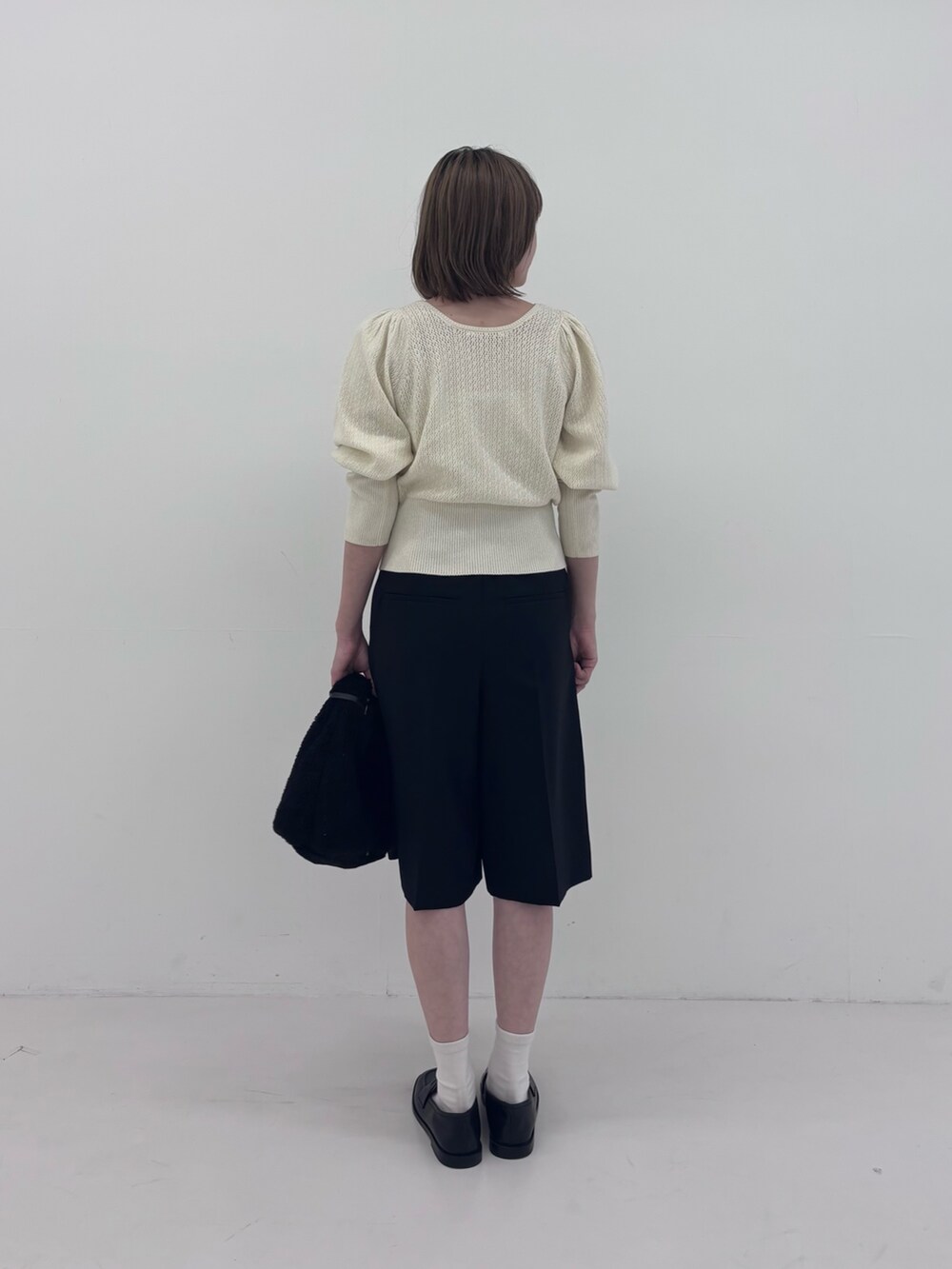 ホワイト系のニット/セーター、ブラック系のその他パンツ、ホワイト系のネックレスを着用したレディースの秋コーディネートの3枚目の写真