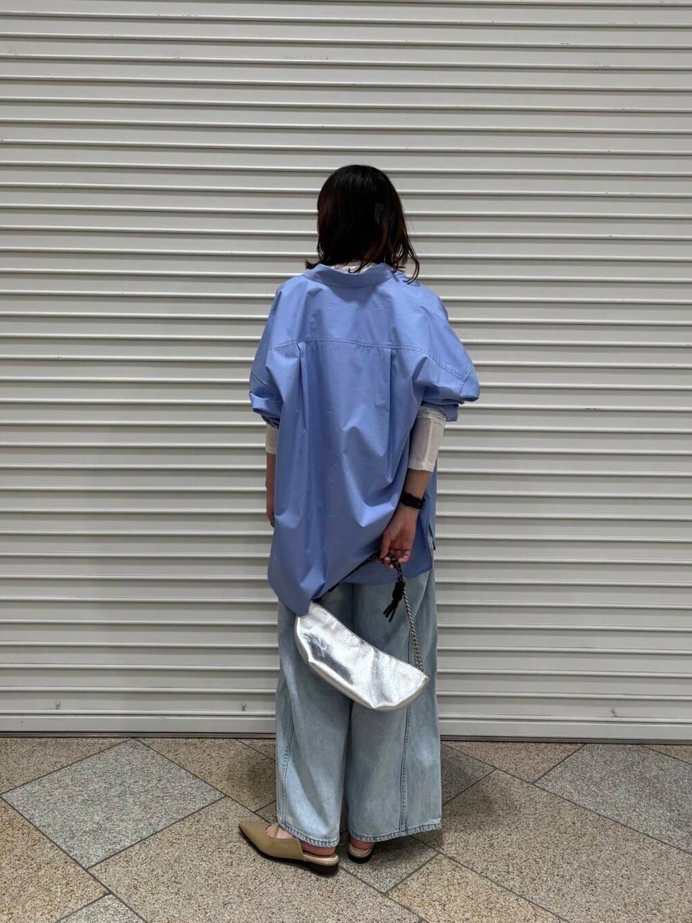 ホワイト系のTシャツ/カットソー、ベージュ系のパンプス、ブルー系のデニムパンツを着用したレディースの冬コーディネートの4枚目の写真