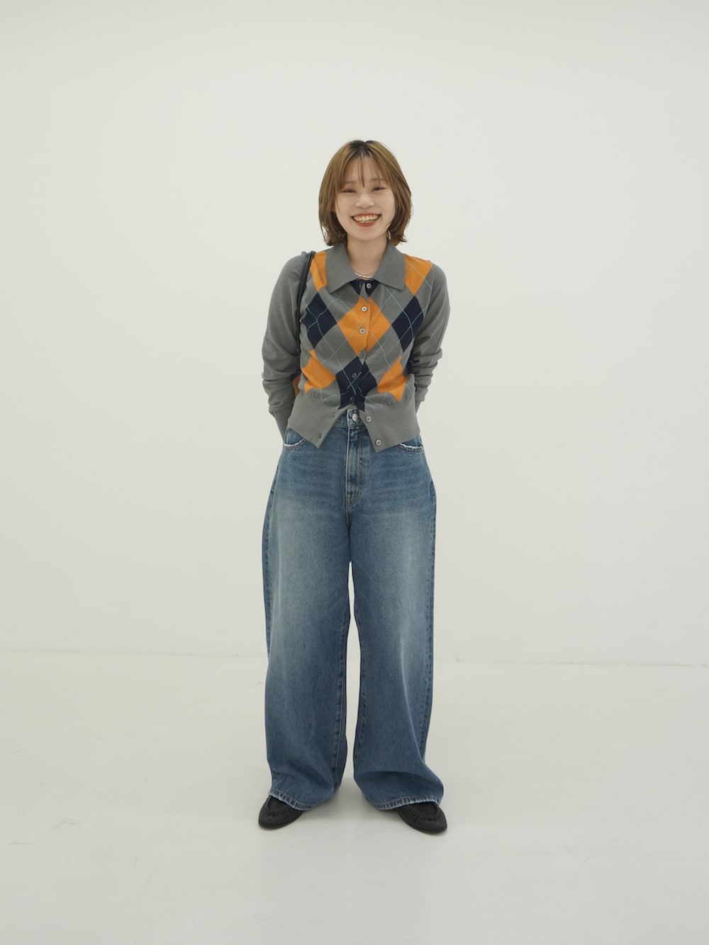 グレー系のカーディガン/ボレロ、ブルー系のデニムパンツ、ブラック系のローファーを着用したレディースの秋コーディネートの2枚目の写真
