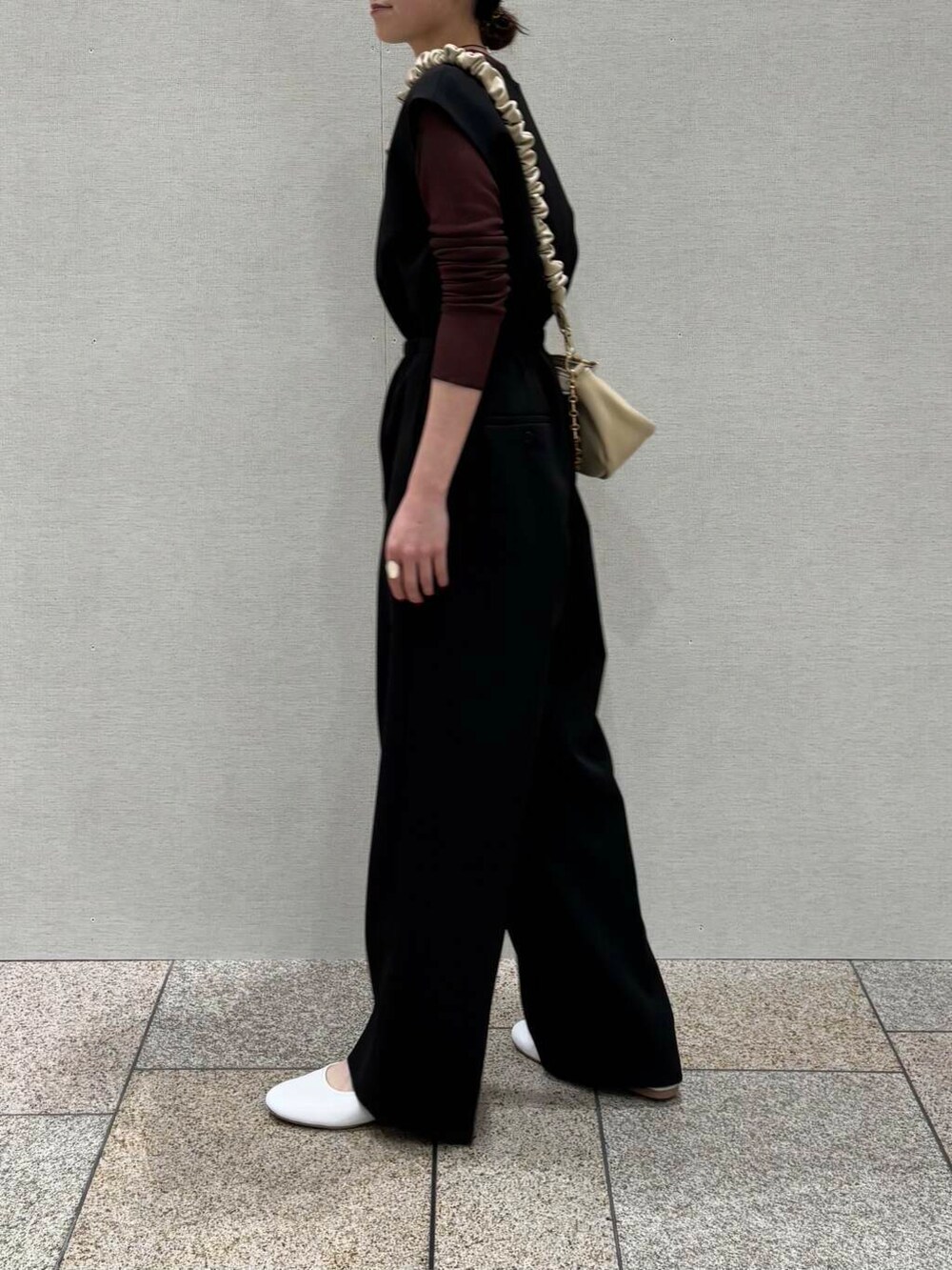 ブラウン系のTシャツ/カットソー、ベージュ系のショルダーバッグ、ブラック系のサロペット/オーバーオールを着用したレディースの冬コーディネートの5枚目の写真