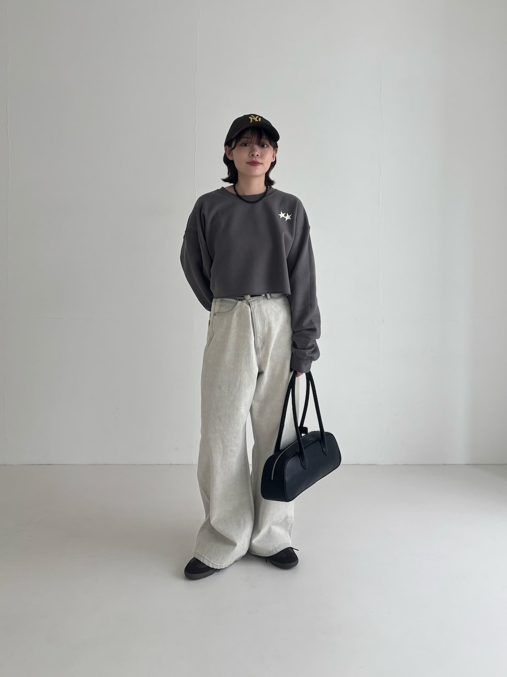 グレー系のデニムパンツ、ブラウン系のスニーカー、グレー系のスウェットを着用したレディースの春コーディネートの3枚目の写真