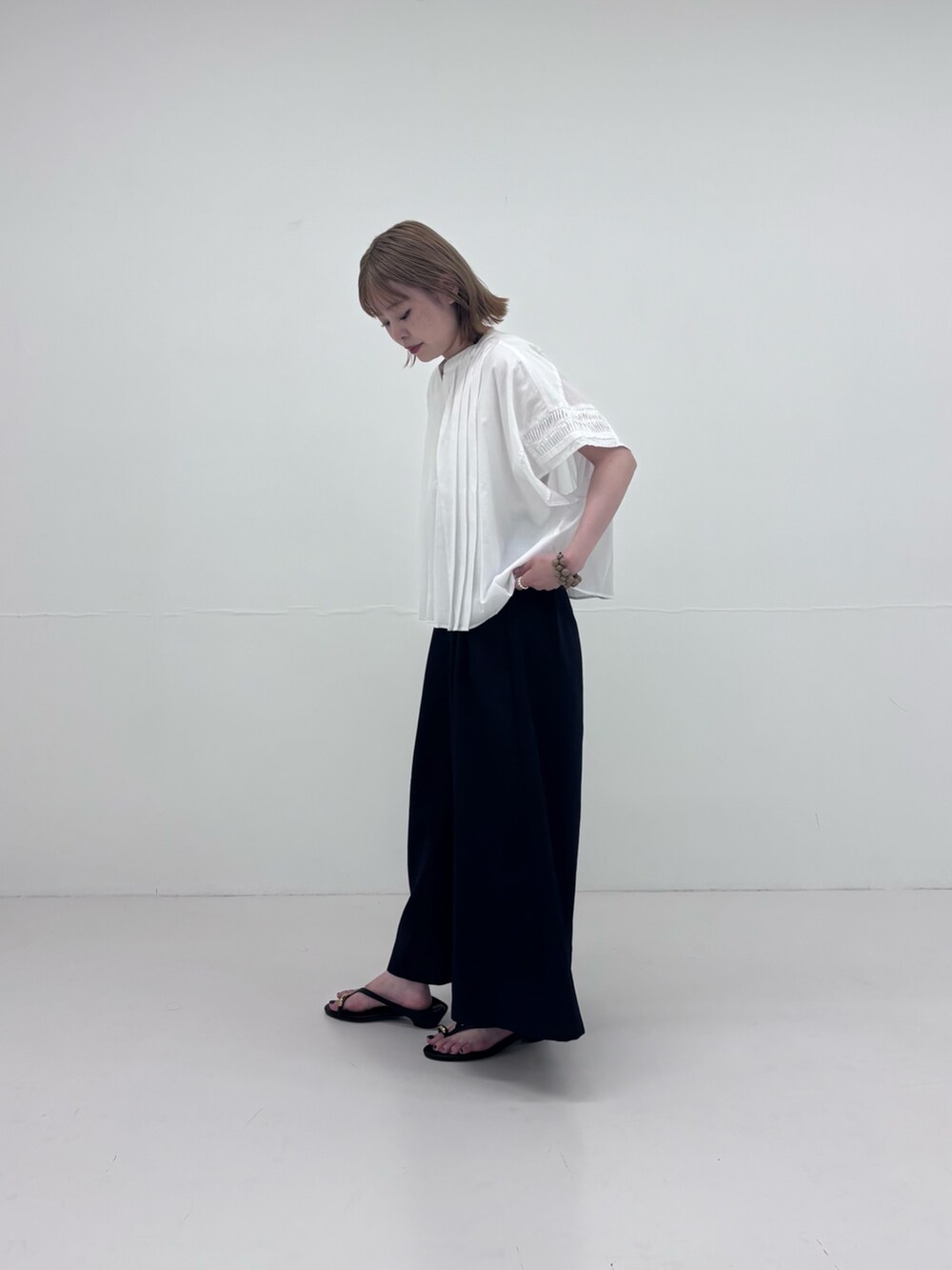 ブラック系のサンダル、ブルー系のその他パンツ、ホワイト系のシャツ/ブラウスを着用したレディースの夏コーディネートの2枚目の写真
