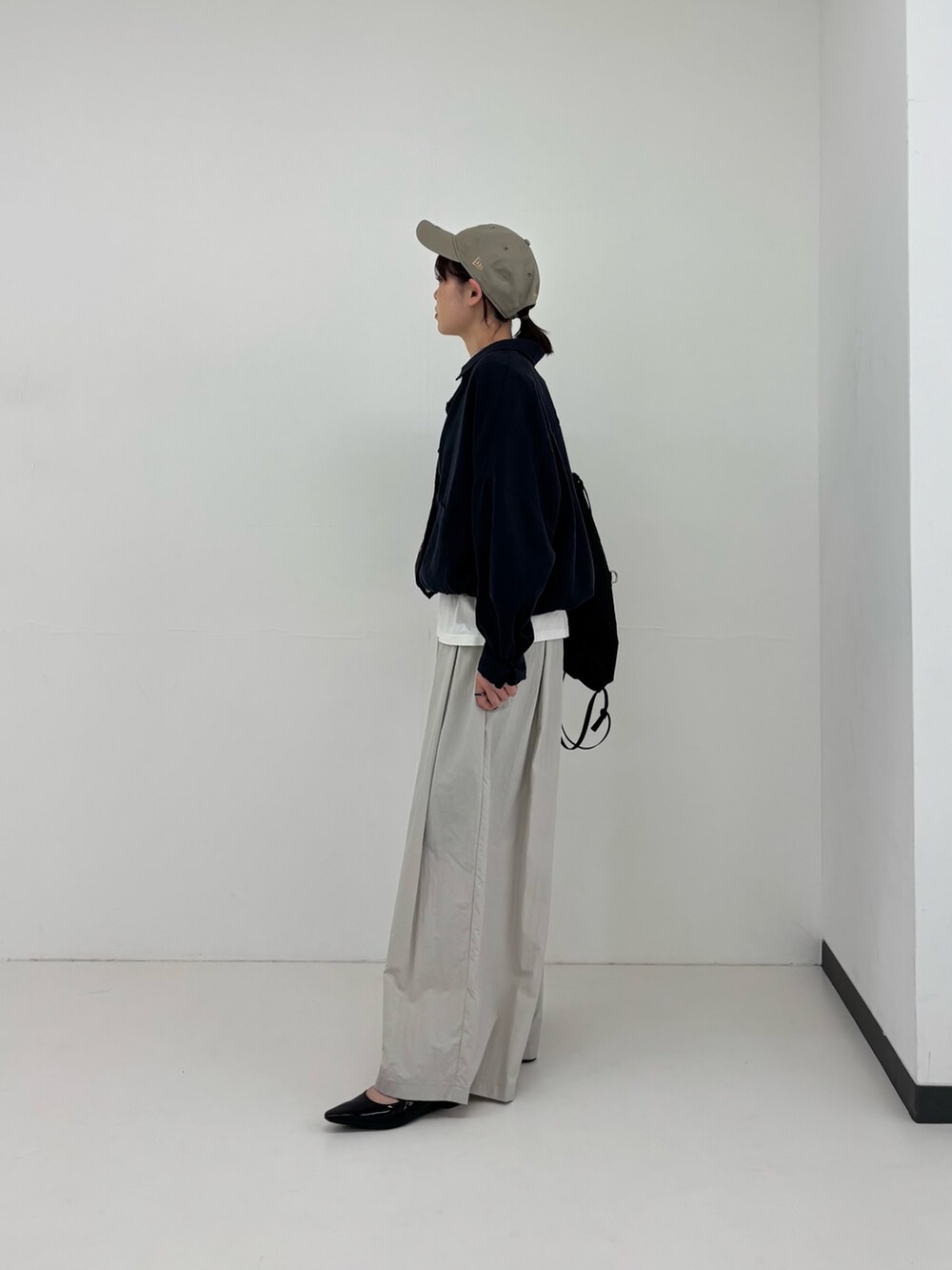 ブラック系のバックパック/リュック、ブラック系のパンプス、ブルー系のシャツ/ブラウスを着用したレディースの春コーディネートの3枚目の写真
