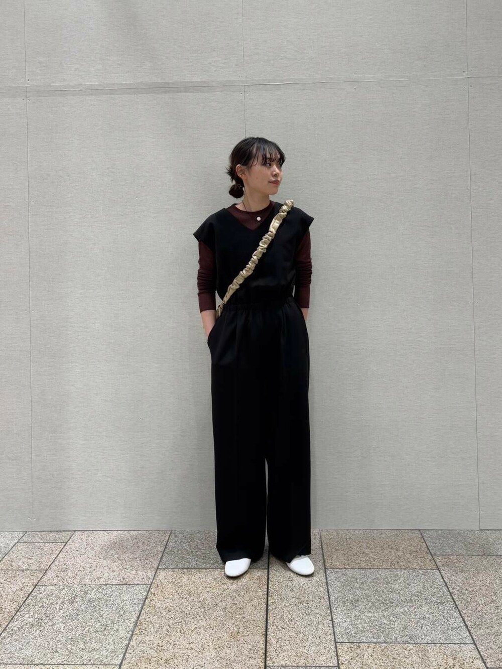 ブラウン系のTシャツ/カットソー、ベージュ系のショルダーバッグ、ブラック系のサロペット/オーバーオールを着用したレディースの冬コーディネートの2枚目の写真