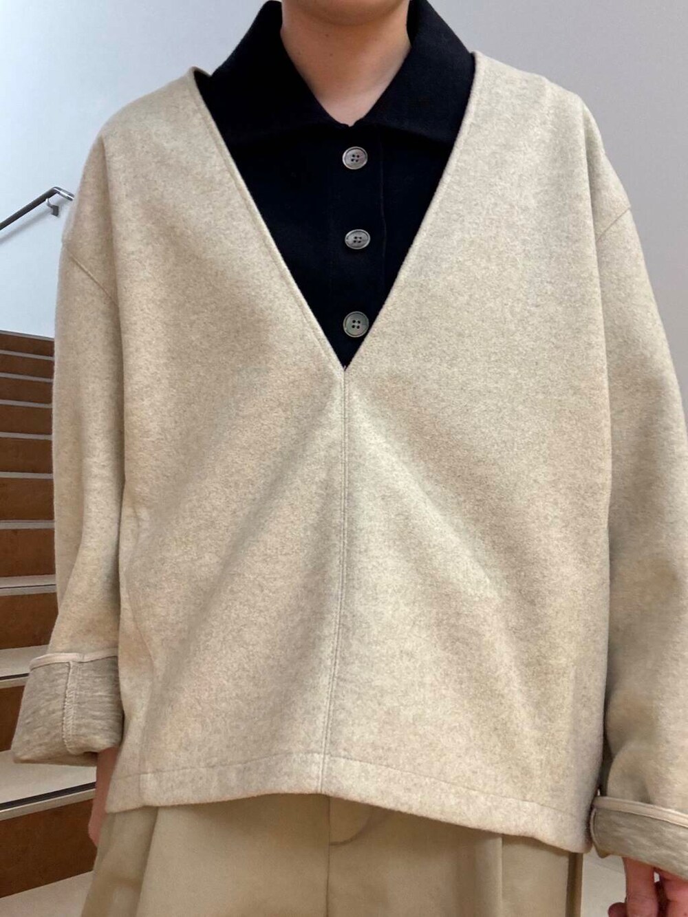 ベージュ系のその他パンツ、ホワイト系のTシャツ/カットソー、ブルー系のニット/セーターを着用したレディースの冬コーディネートの4枚目の写真