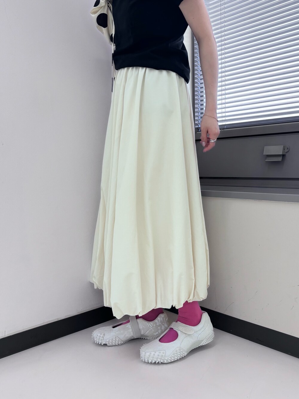 グレー系のスニーカー、ホワイト系のスカートを着用したレディースの夏コーディネートの3枚目の写真