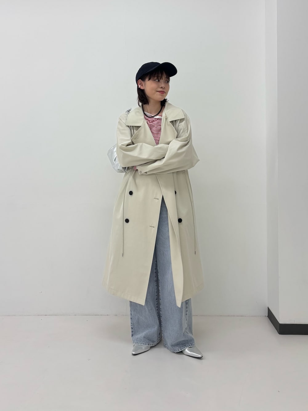 ベージュ系のトレンチコート、ブルー系のデニムパンツ、レッド系のTシャツ/カットソーを着用したレディースの春コーディネートの4枚目の写真
