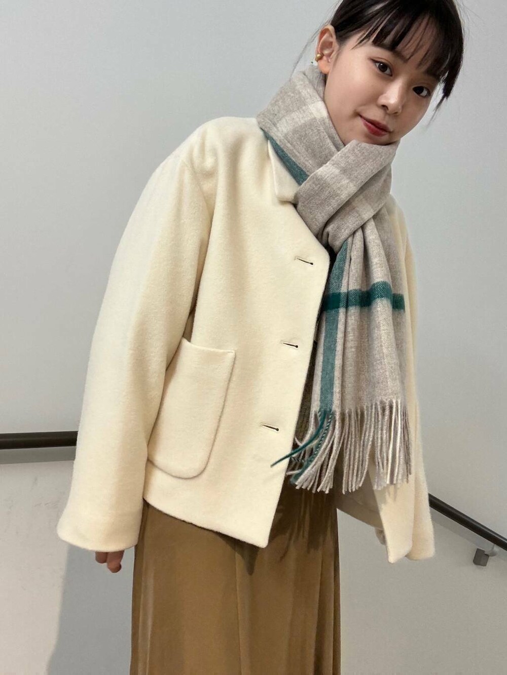 ホワイト系のその他アウター、イエロー系のスカート、ホワイト系のカーディガン/ボレロを着用したレディースの冬コーディネートの9枚目の写真