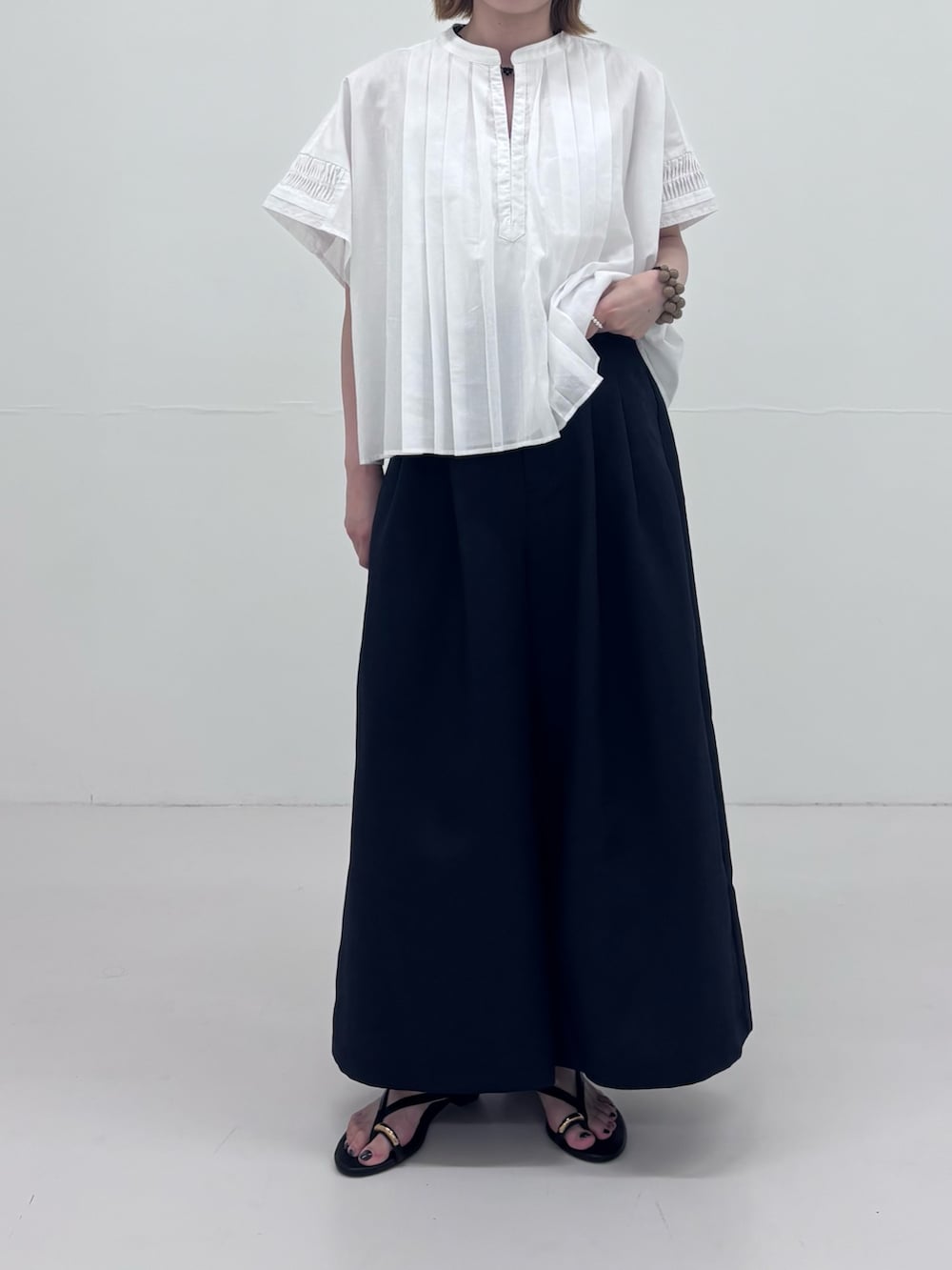 ブラック系のサンダル、ブルー系のその他パンツ、ホワイト系のシャツ/ブラウスを着用したレディースの夏コーディネートの3枚目の写真