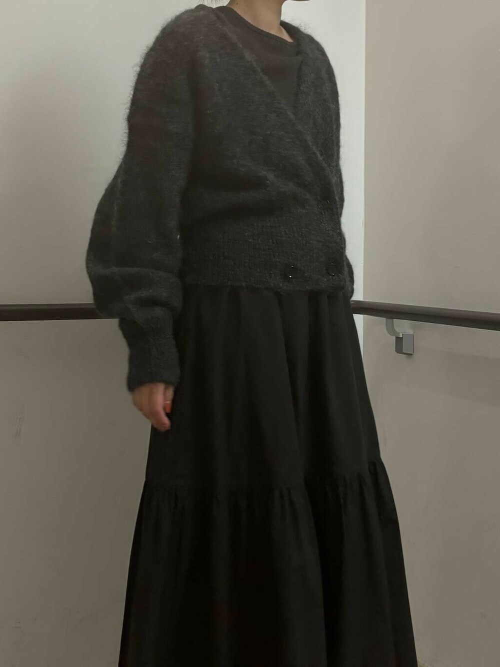 ブラック系のスカート、グリーン系のニット/セーター、グレー系のカーディガン/ボレロを着用したレディースの秋コーディネートの4枚目の写真