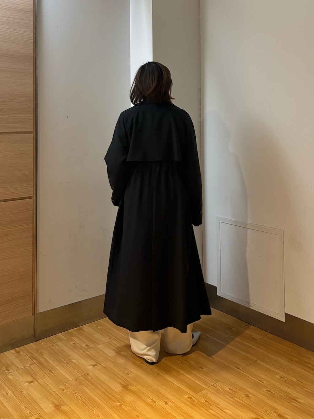 ブラック系のトレンチコート、ホワイト系のその他パンツ、ホワイト系のニット/セーターを着用したレディースの冬コーディネートの5枚目の写真