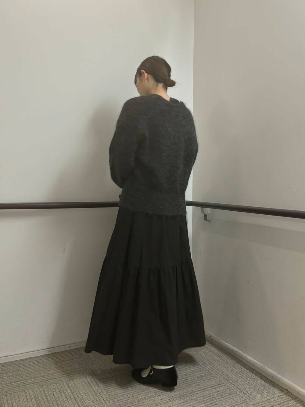 ブラック系のスカート、グリーン系のニット/セーター、グレー系のカーディガン/ボレロを着用したレディースの秋コーディネートの3枚目の写真