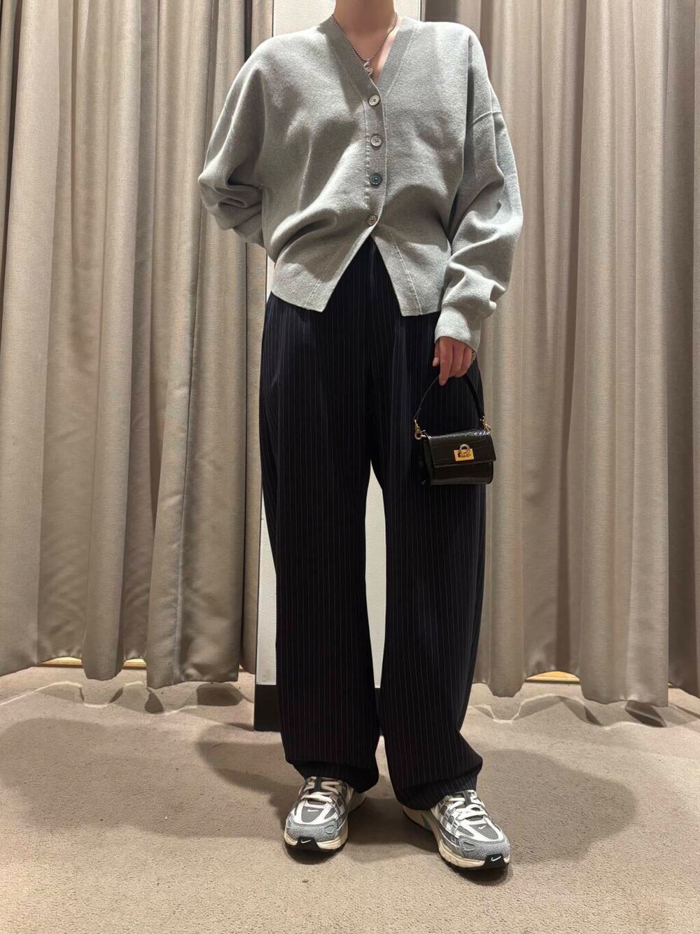 ブラック系のショルダーバッグ、ブルー系のその他パンツ、グレー系のカーディガン/ボレロを着用したレディースの冬コーディネートの2枚目の写真