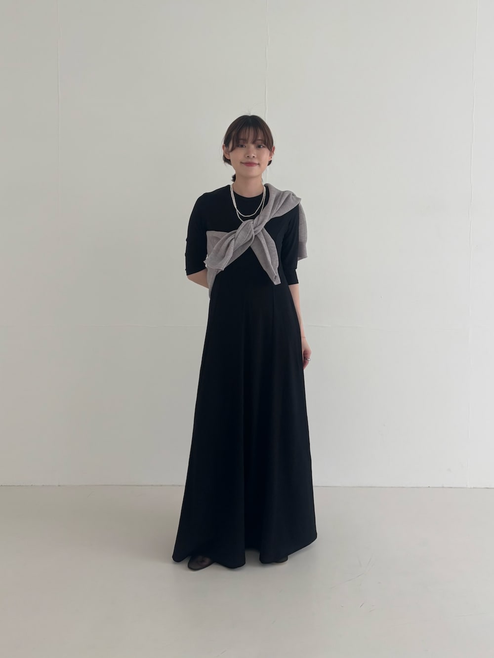 ブラック系のワンピース、ブラック系のその他アウター、グレー系のニット/セーターを着用したレディースの春コーディネートの4枚目の写真