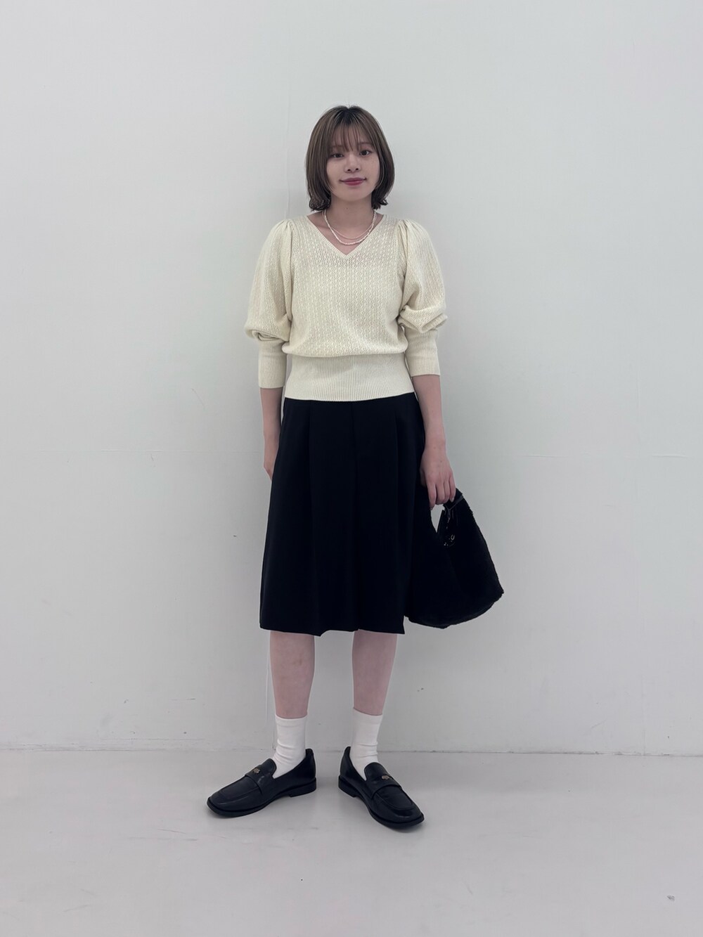ホワイト系のニット/セーター、ブラック系のその他パンツ、ホワイト系のネックレスを着用したレディースの秋コーディネートの2枚目の写真
