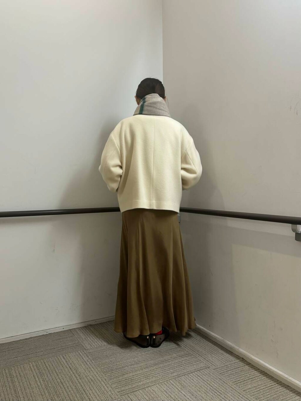 ホワイト系のその他アウター、イエロー系のスカート、ホワイト系のカーディガン/ボレロを着用したレディースの冬コーディネートの5枚目の写真