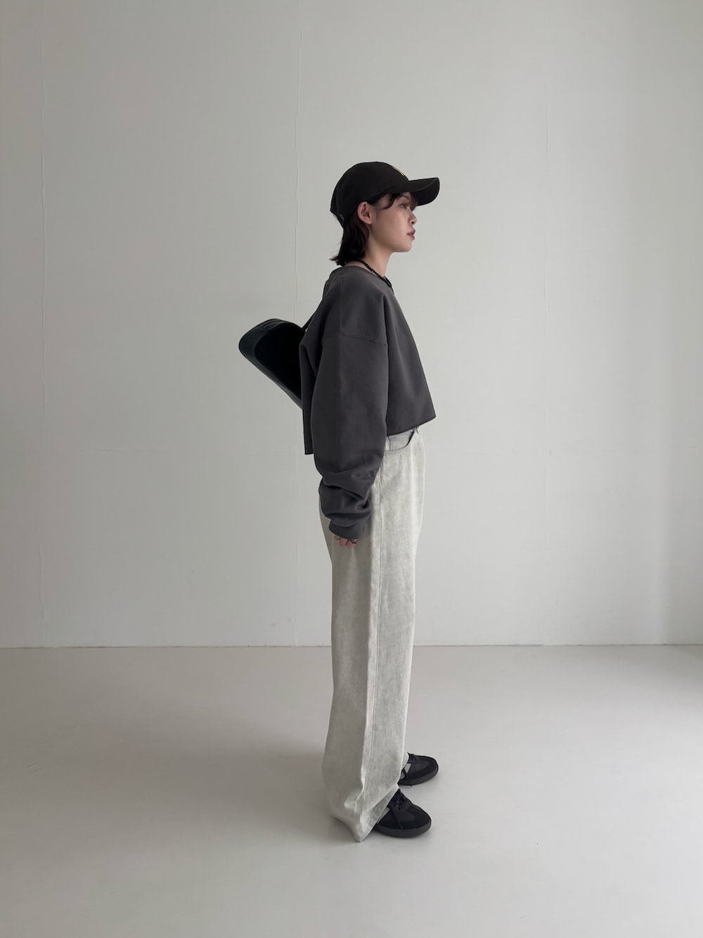 グレー系のデニムパンツ、ブラウン系のスニーカー、グレー系のスウェットを着用したレディースの春コーディネートの4枚目の写真