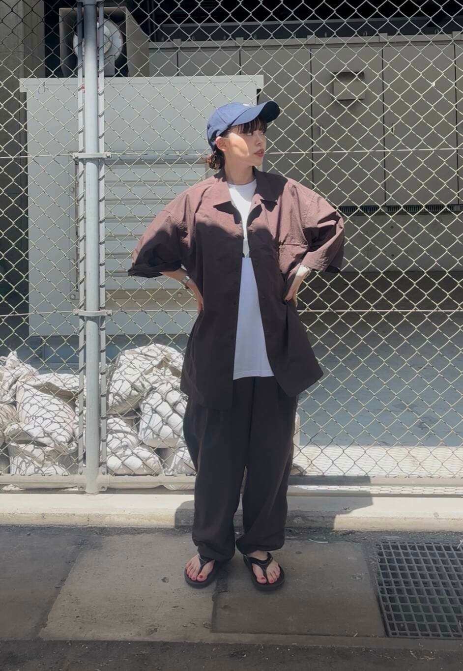 ブラック系のサンダル、ホワイト系のTシャツ/カットソー、ブラウン系のその他パンツを着用したレディースの夏コーディネートの3枚目の写真