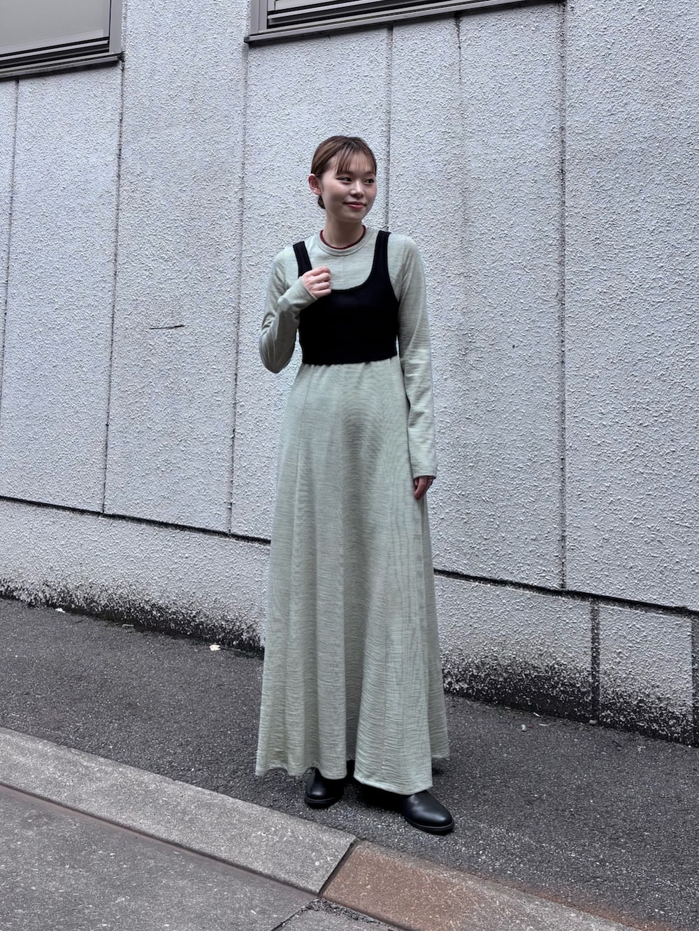 ベージュ系のダウンジャケット/コート、ホワイト系のワンピース、ブラック系のニット/セーターを着用したレディースの秋コーディネートの5枚目の写真